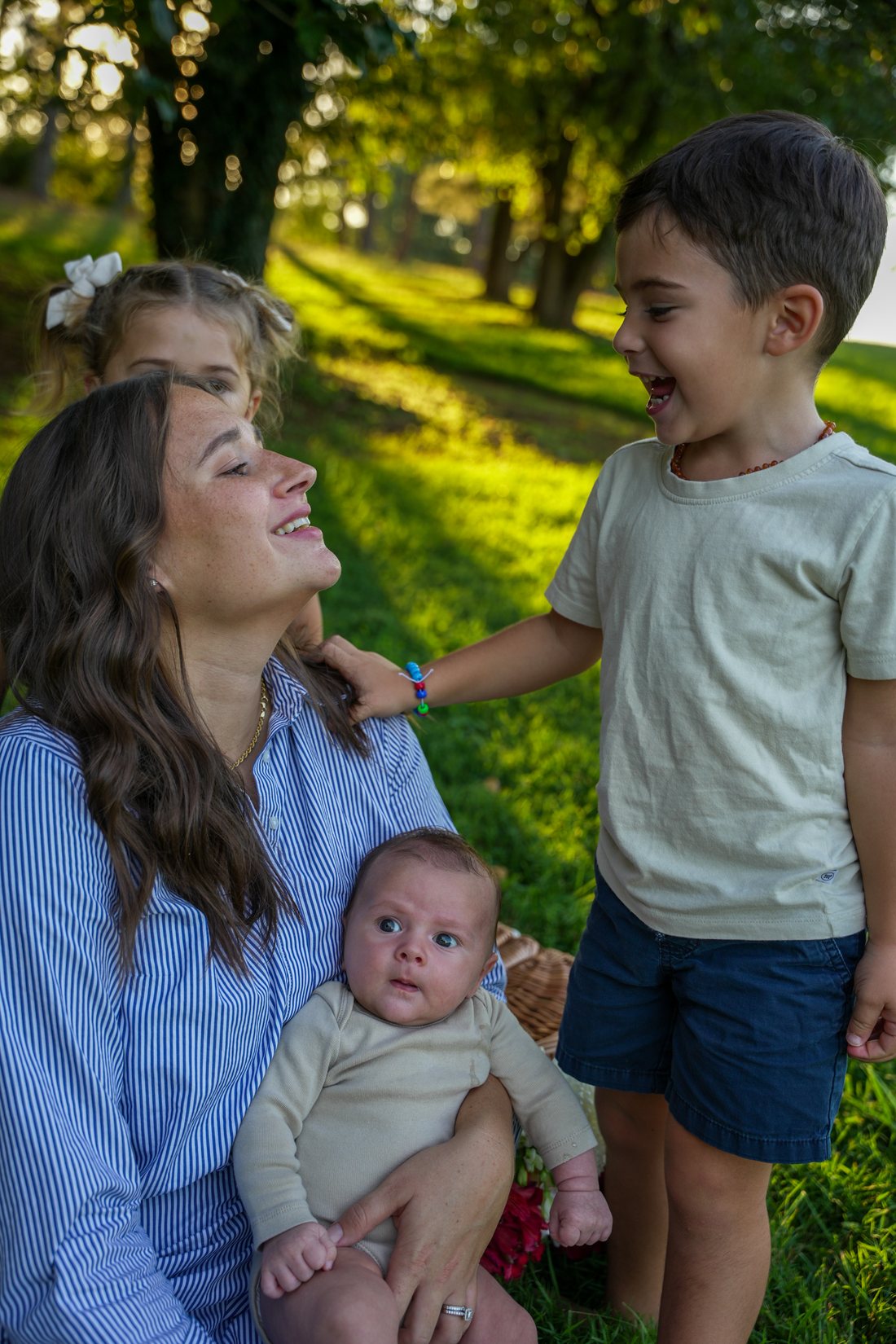 Family laughing together in a sunlit park